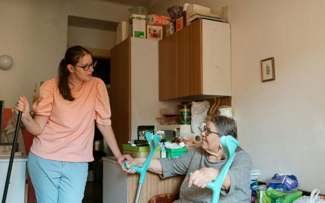 24-Stunden-Betreuung zu Hause Seniorin zu Hause mit Betreuungskraft am Esstisch in vertrauter Umgebung
