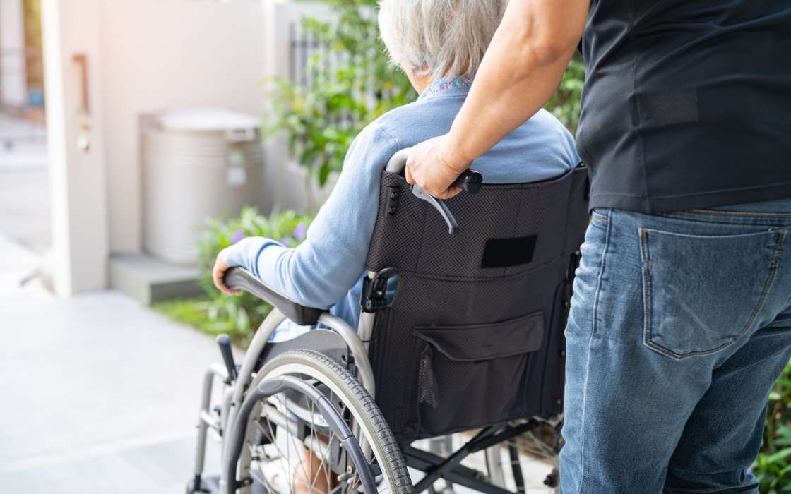 Seniorin sitzt zu Hause mit Betreuungskraft am Tisch und spricht über den Alltag