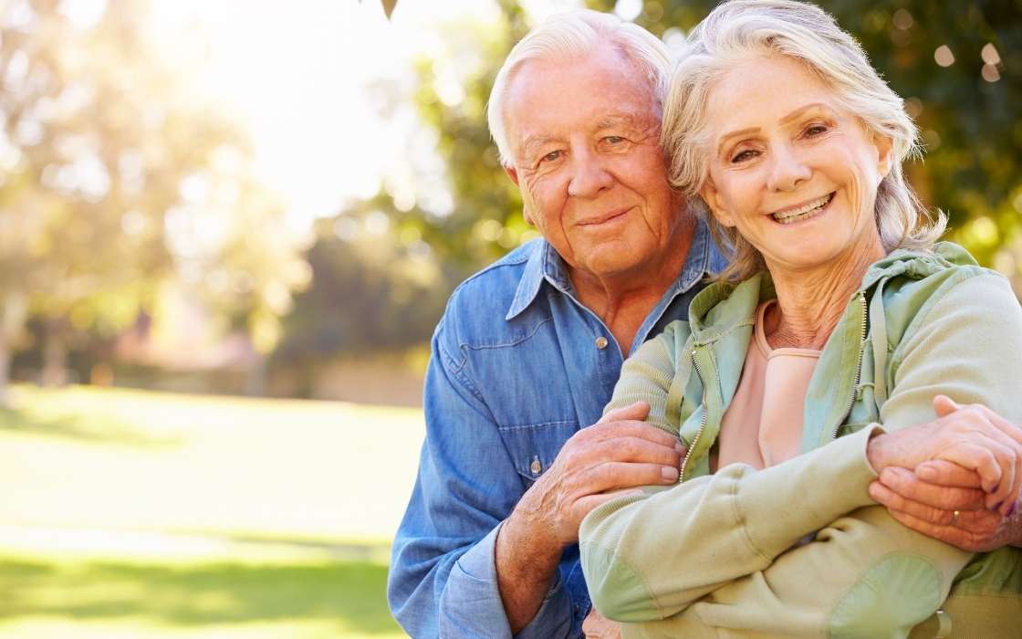 Betreuungskraft spielt mit Senior ein Brettspiel am Tisch und fördert geistige Aktivität