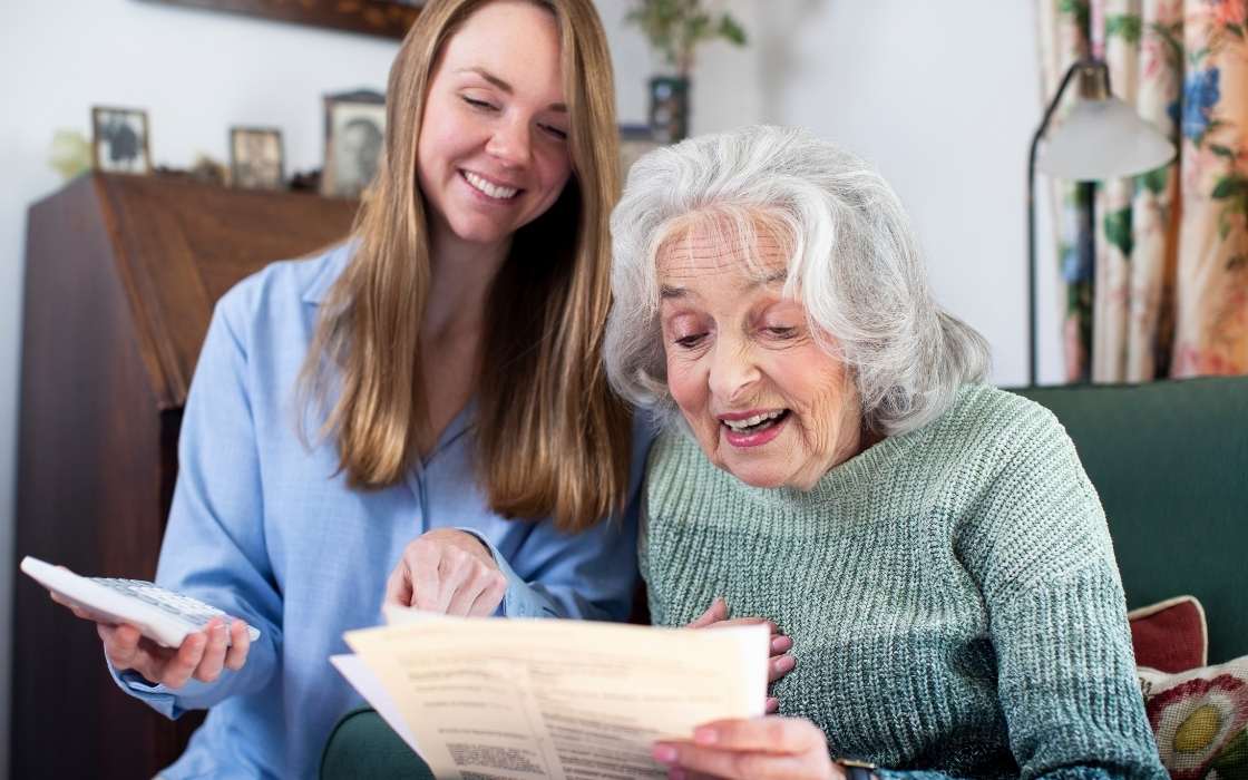 Betreuung Qualität erkennen Angehörige sprechen mit einer Betreuungskraft über den Alltag eines Seniors