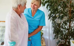 Betreuungskraft begleitet einen Senior im Alltag und unterstützt bei kleinen Aufgaben