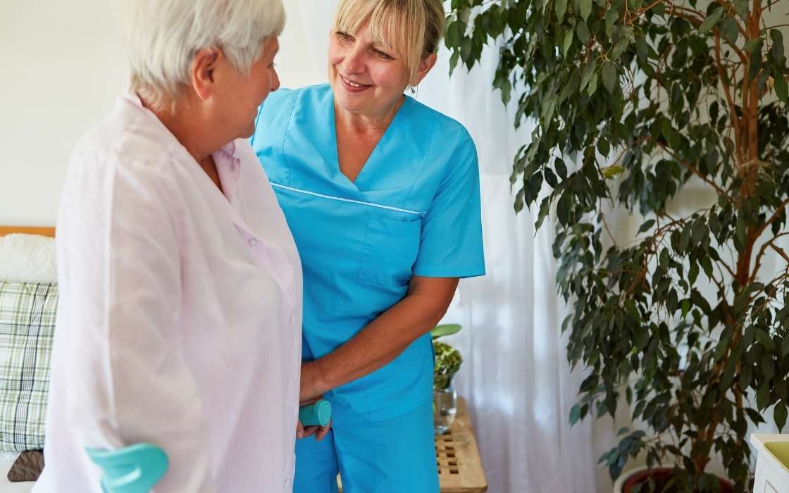 Betreuungskraft begleitet einen Senior im Alltag und unterstützt bei kleinen Aufgaben