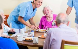 Betreuungskraft unterstützt Senior im Alltag, Haushaltshilfe erledigt Hausarbeit