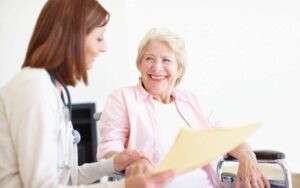 Betreuungskraft begleitet Seniorin mit Demenz liebevoll im Alltag zu Hause