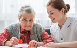 Angehörige begrüssen Betreuungskraft im Zuhause eines Seniors bei der Eingewöhnung