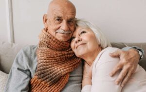 Seniorin trägt einen Notrufknopf am Handgelenk in der Wohnung und fühlt sich sicherer