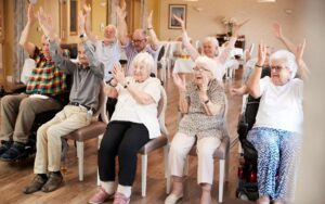 Senior beschäftigt sich zuhause mit einer Betreuungskraft bei einer gemeinsamen Aktivität