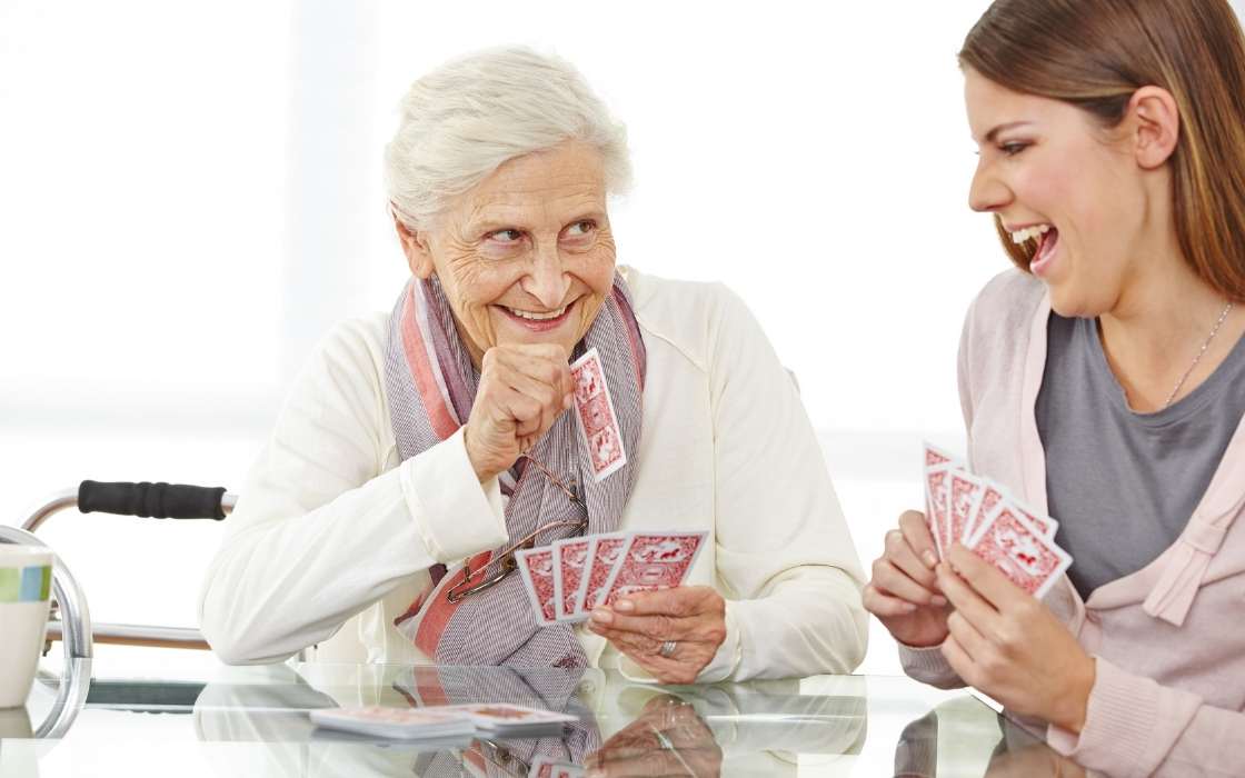 Angehörige sprechen mit Betreuungsperson am Esstisch über Betreuung